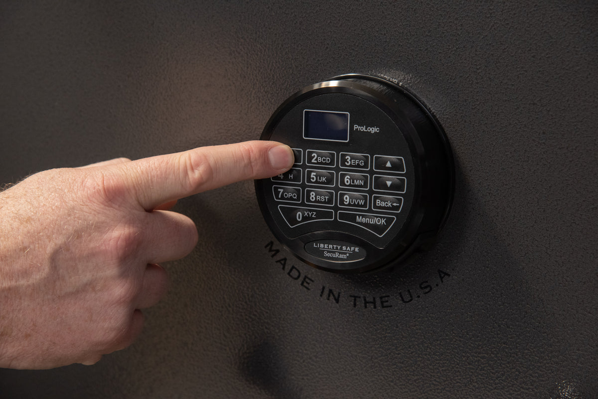Close-up of a hand pressing buttons on an electronic keypad lock on a Liberty Safe door