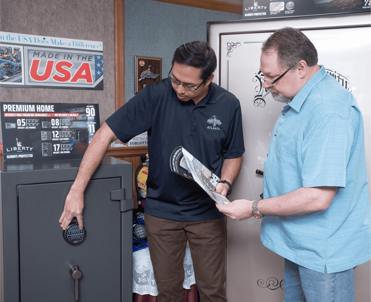 Two people in a safe showroom reviewing information beside a safe, illustrating why The SafeMarket created its own safe rating system.