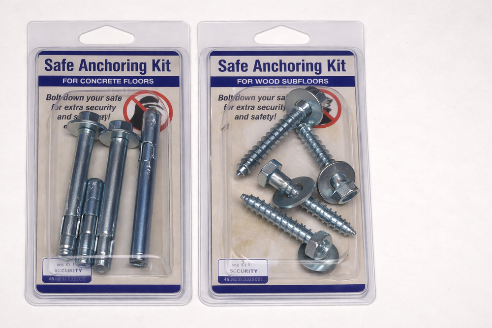 Two packaged safe anchoring kits—one for concrete floors and one for wood subfloors—showing bolts and lag screws used to secure a safe and prevent tipping or removal.